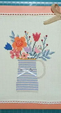Cross stitch painting. Jar with flowers.